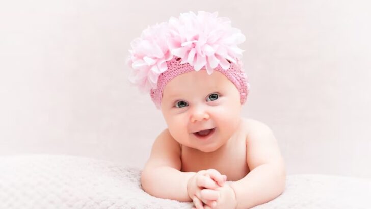 Bebê de faixa rosa na cabeça sorrindo para foto