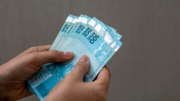 pessoa contando notas de 100 reais