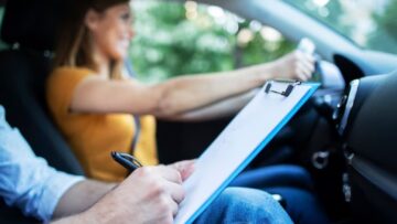 Mulher dirigindo carro para tirar CNH