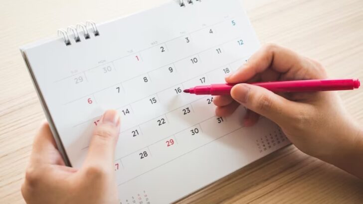 Pessoa segurando um calendário e uma caneta