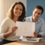 Pessoa brasileira sorrindo com certificado e laptop em ambiente de estudo representando cursos gratuitos FGV que aumentam as chances de emprego