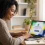 Mulher brasileira sorrindo usando um laptop enquanto faz inscrição online na plataforma Aprenda Mais MEC com uma pequena bandeira do Brasil ao lado