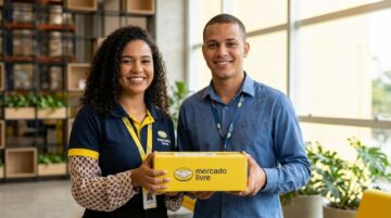 Dois jovens brasileiros sorrindo segurando uma caixa do Mercado Livre em um escritório, representando oportunidade de vaga de Jovem Aprendiz