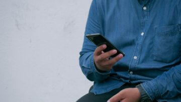 Homem segurando smartphone na mão